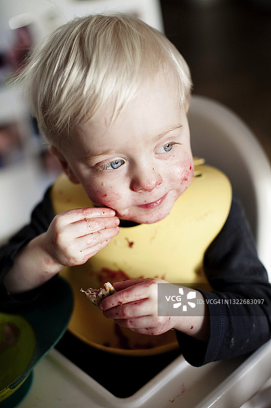 坐在高脚椅上吃饭的男孩图片素材