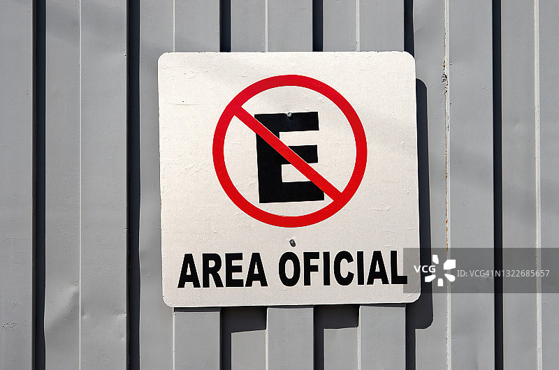 灰色金属门上的西班牙语标牌：禁止停车，官方区域图片素材
