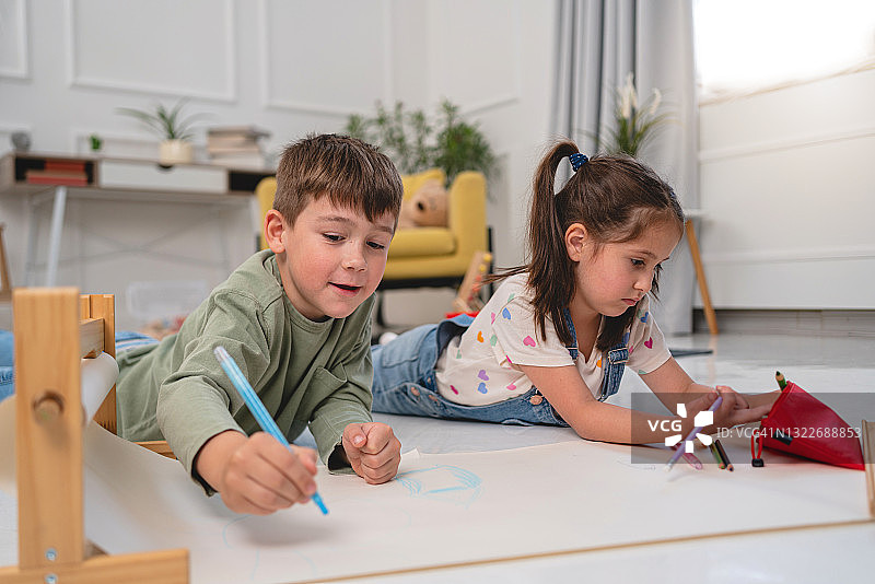 蒙特梭利幼儿园里，孩子们一起在纸上绘画，以有趣的方式培养创造力图片素材