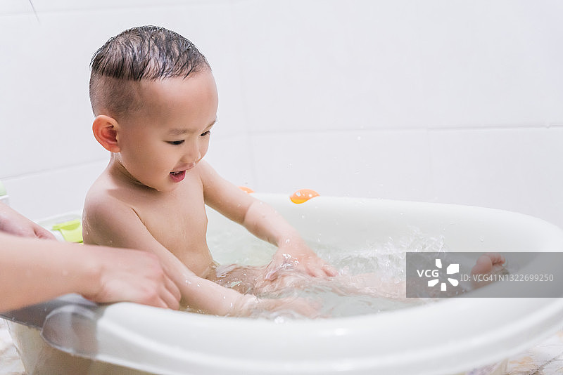 亚洲母亲给儿子洗澡图片素材