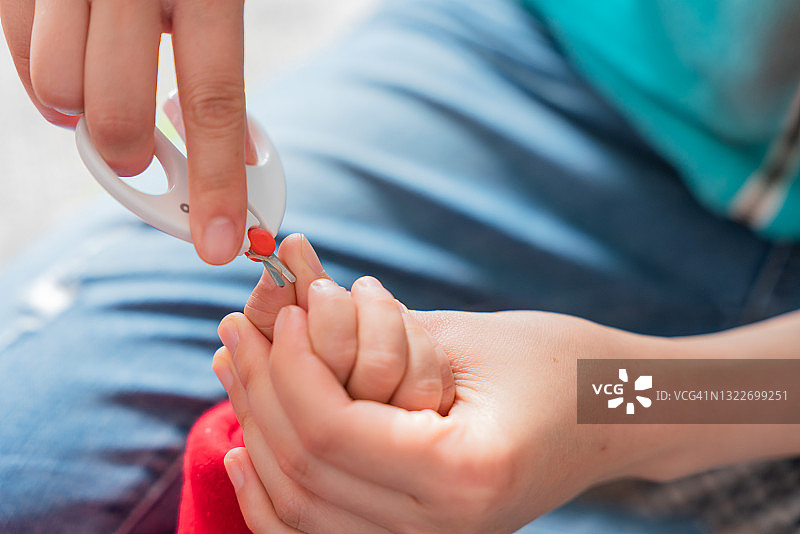 亚洲母亲给儿子剪指甲图片素材