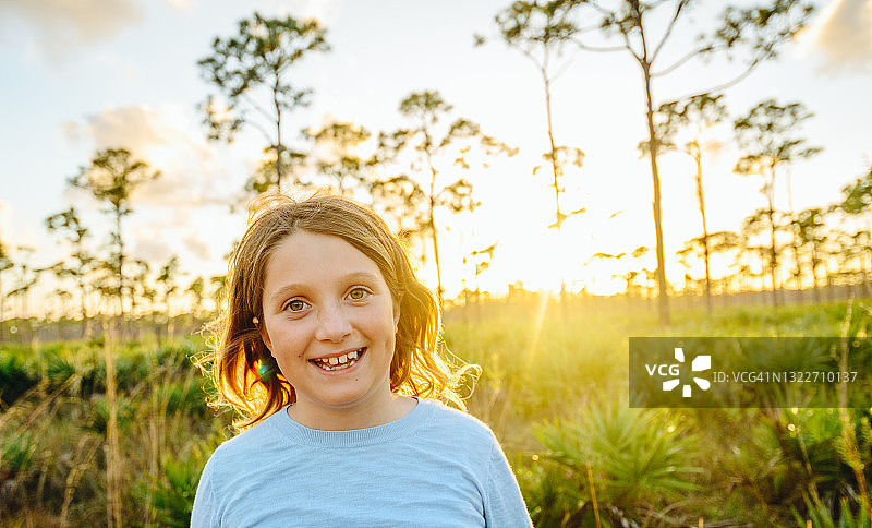 在乡村森林黄昏时分拍摄的可爱小学生女孩肖像图片素材