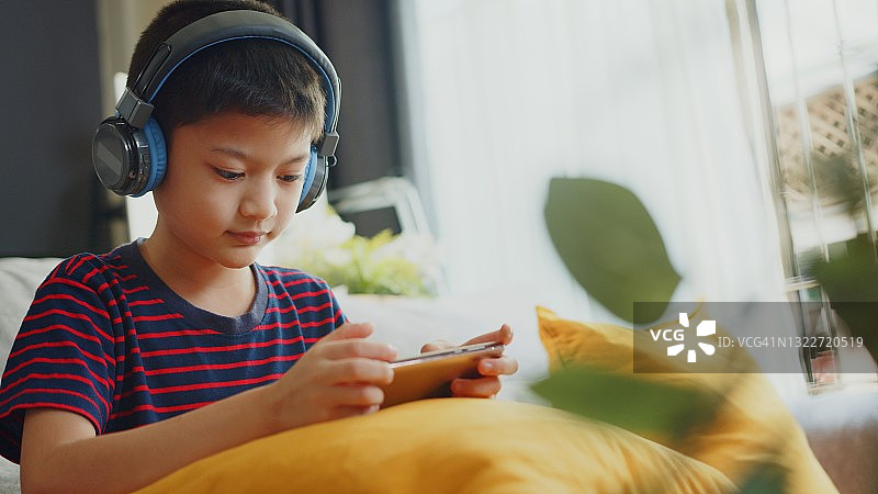 阿尔法世代男孩在家用手机学习图片素材