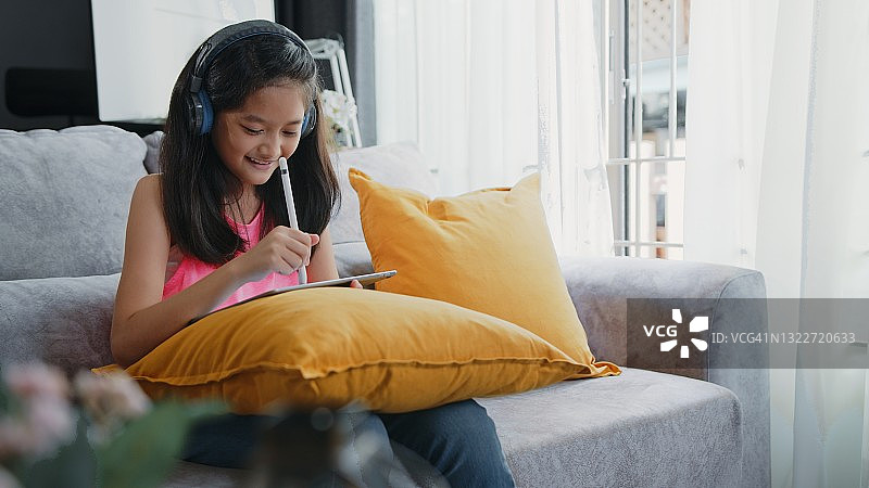 自信快乐的女孩在家与弟弟在数位板上绘画图片素材