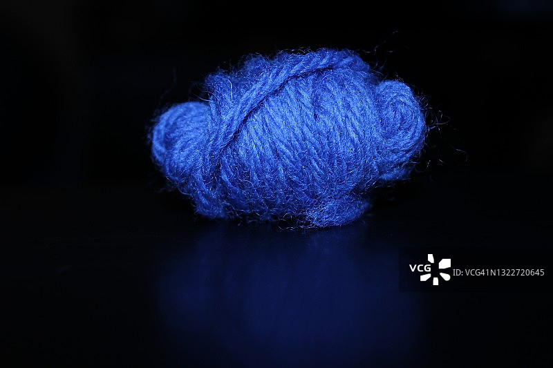 黑色背景上的蓝色小毛线球图片素材