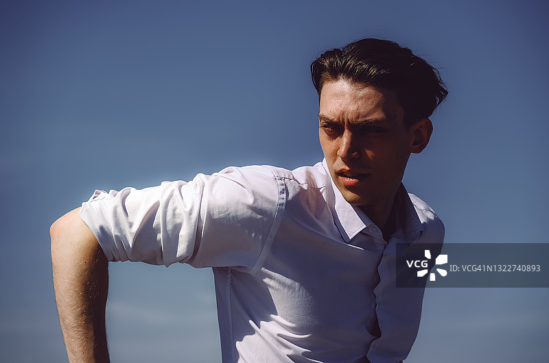 年轻男人在城市公园木制河堤上享受夏日阳光图片素材