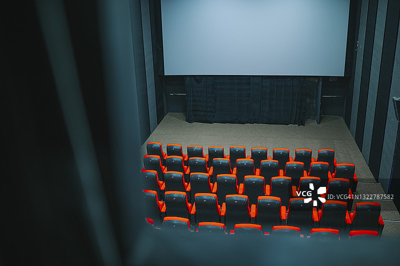 透过放映室的窗户俯视空旷的电影院和白色屏幕图片素材