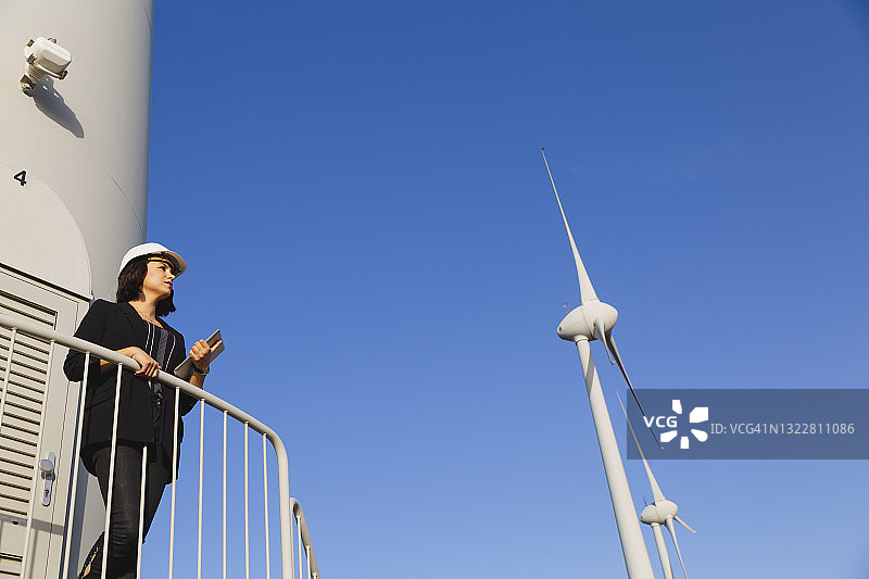 女商人用平板检查风力发电机图片素材
