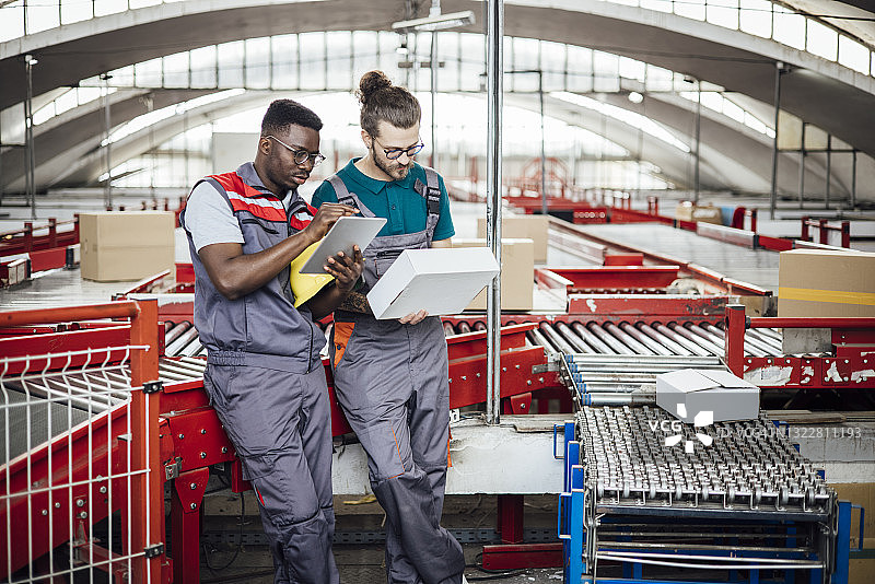 仓库里整理存储的两名年轻工人图片素材