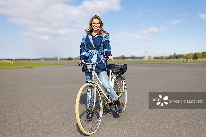 在滕珀尔霍夫机场骑自行车的女人图片素材