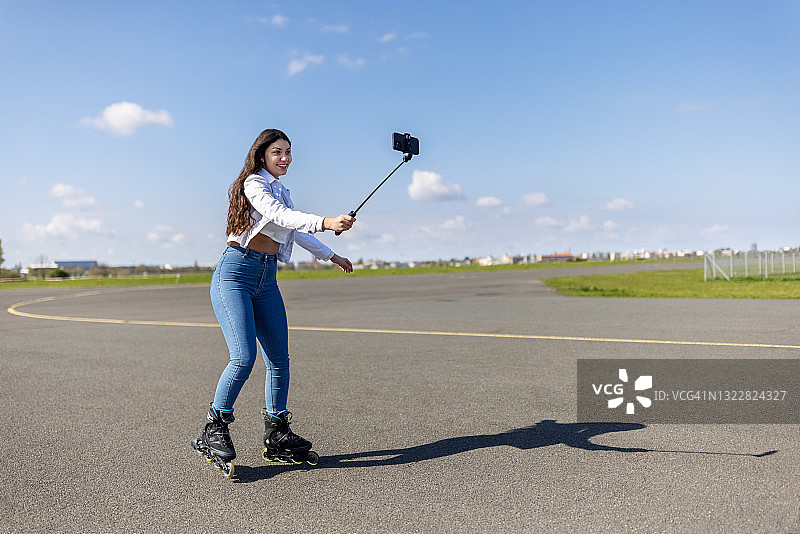 在滕珀尔霍夫机场跑道上滑冰时自拍的少女图片素材