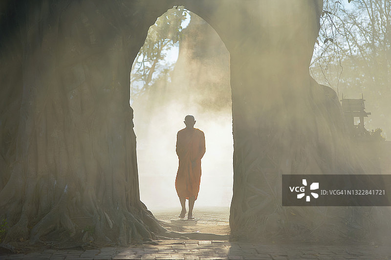 泰国寺庙建筑群中雾中的僧侣剪影图片素材