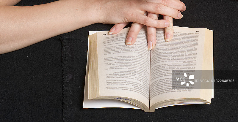 女人手拿平装书图片素材