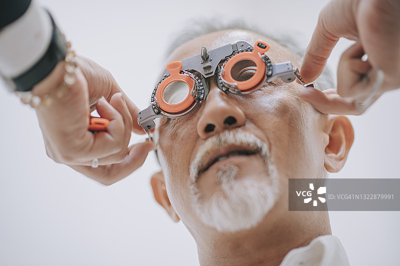 亚洲老年男性患者在眼科诊所检查视力图片素材