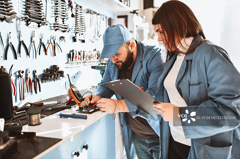男女电子工程师检查零件成功率统计数据图片素材