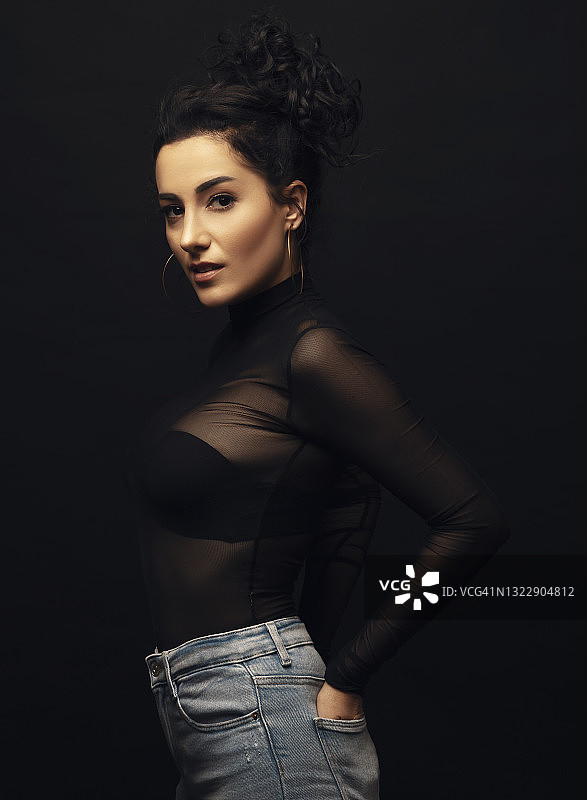 双手插在后口袋里看着镜头的年轻漂亮女人图片素材