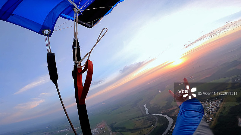 日出时分跳伞运动员打开降落伞的视角图片素材