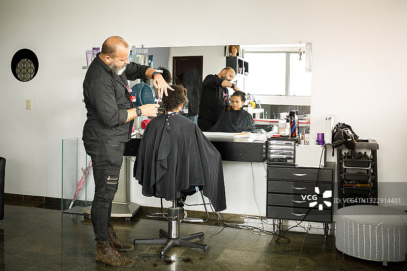 男发型师在美发沙龙为女性理发肖像图片素材