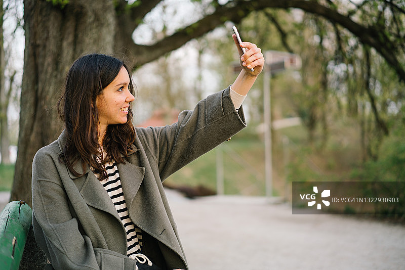 年轻女人走过秋季的城市公园图片素材
