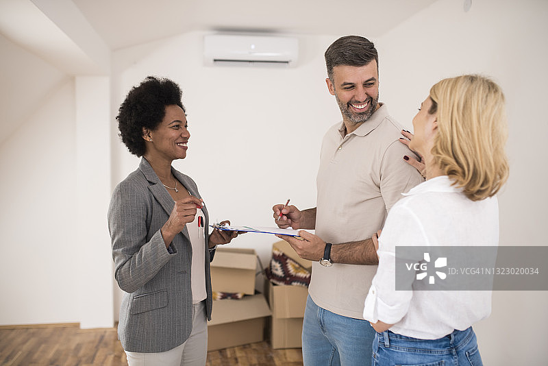 快乐的男人与妻子签署购买新房合同图片素材