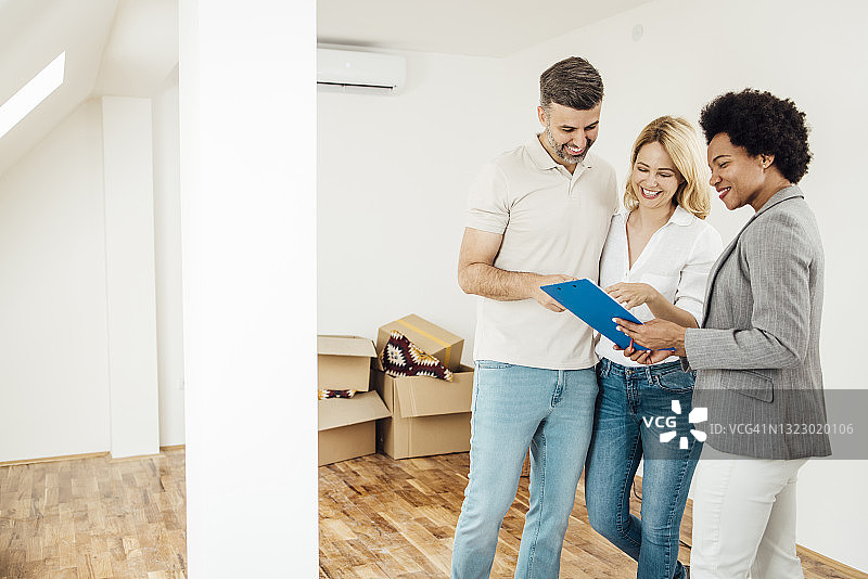 幸福情侣与房地产经纪人核对购买合同图片素材