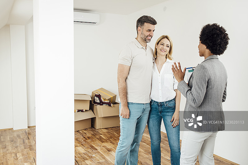 幸福的夫妇从一位非裔美国人经纪人那里购买新公寓图片素材