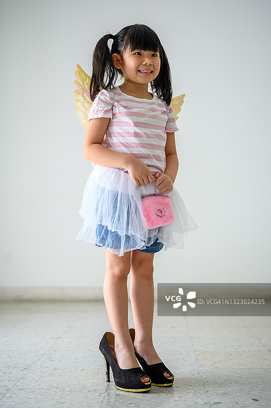 穿着高跟鞋的可爱亚洲小女孩去购物图片素材