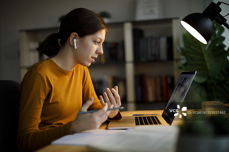 戴蓝牙耳机上网课的少女图片素材