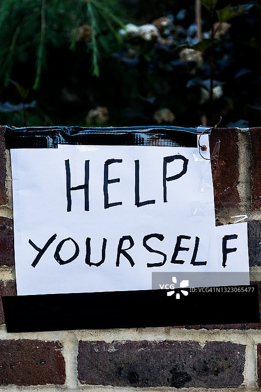 砖墙上写着“自助”的纸条图片素材