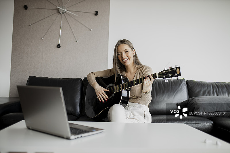 在家学习在线吉他的女人图片素材