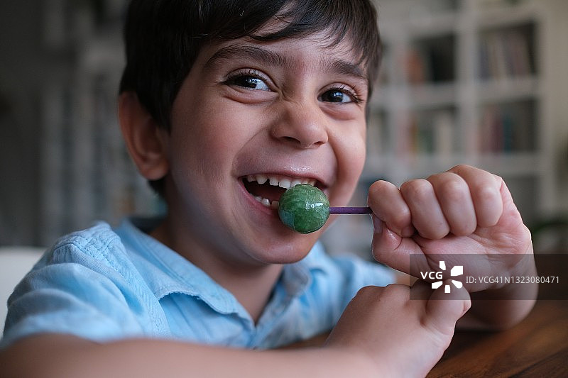 可爱的小男孩正在吃棒棒糖图片素材