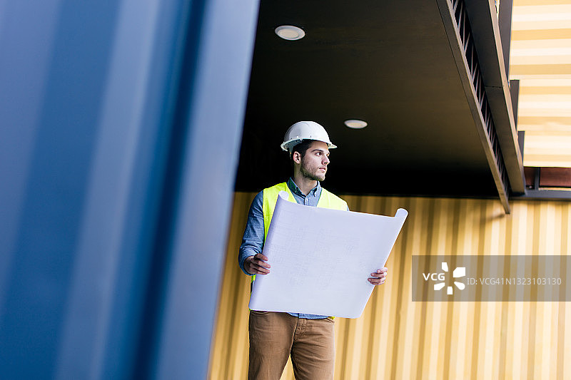 男土木工程师拿着图纸，看向远方图片素材