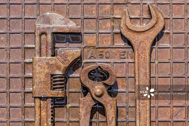 德国潮湿生锈铁板上的旧工具：钳子、扳手图片素材