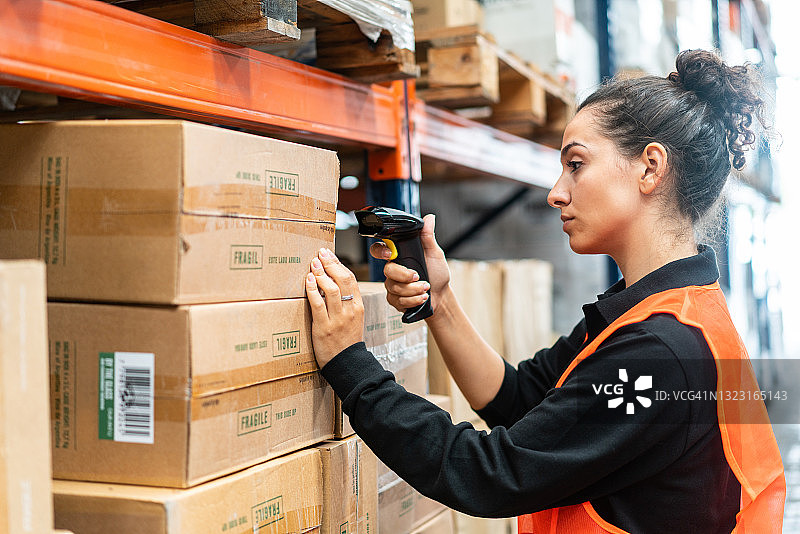 仓库工人用扫描仪在货架上检查货物图片素材