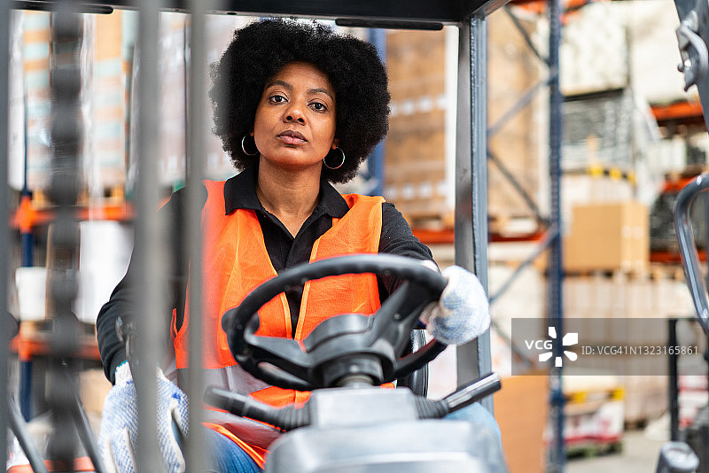 女人在仓库里驾驶叉车图片素材