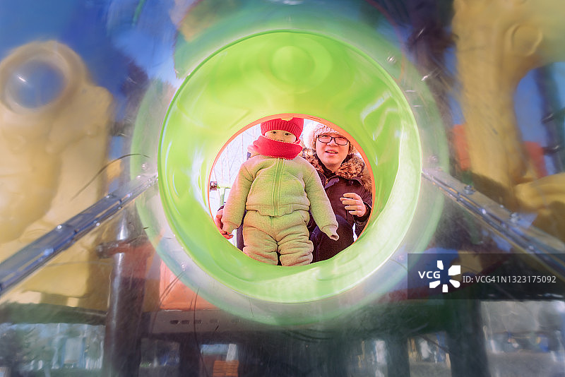 冬天，妈妈和儿子在游乐场玩耍图片素材