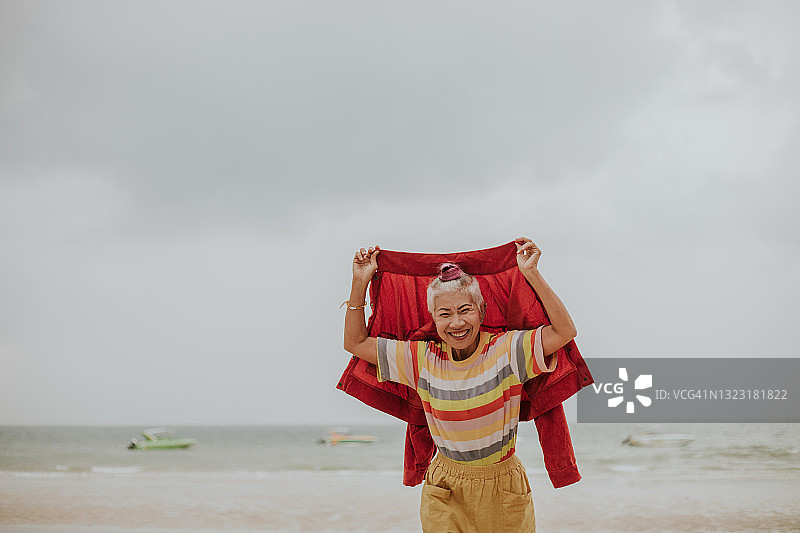 穿着鲜艳服装微笑的年长古怪女游客照片图片素材