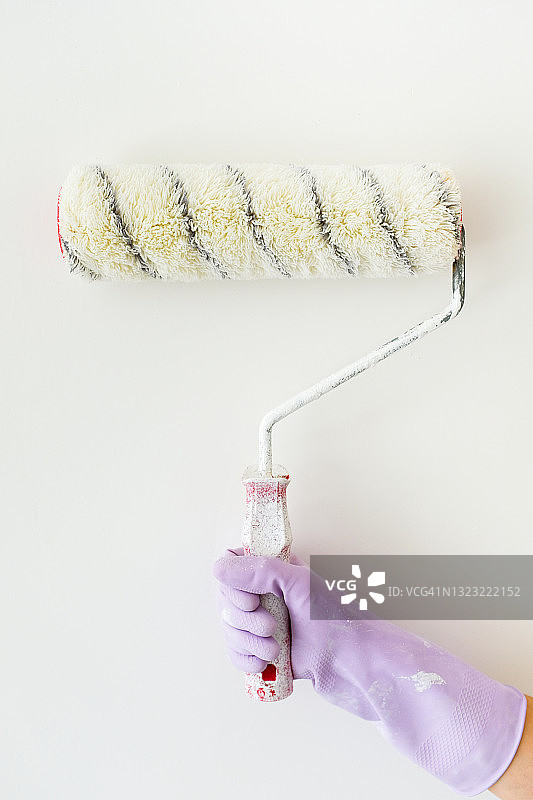 油漆工手中的白色油漆滚筒图片素材