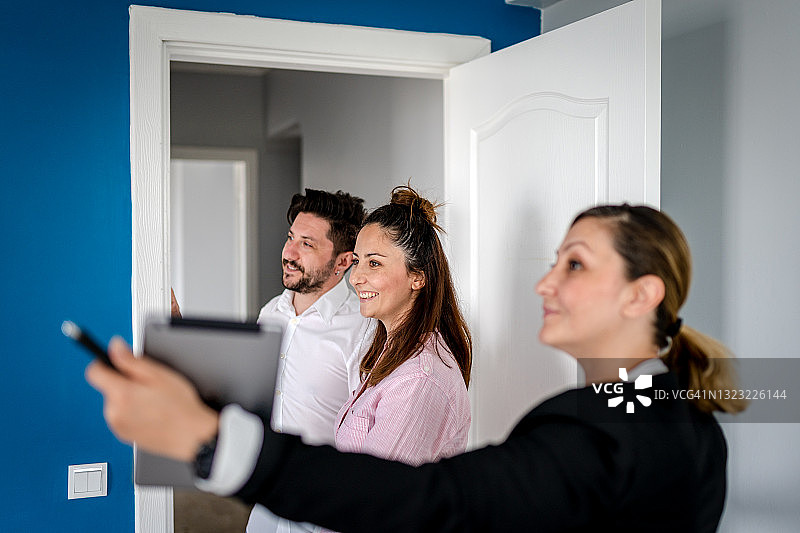 房地产中介向幸福的家庭展示房产图片素材