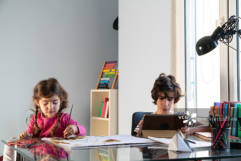兄妹在客厅里在家上学图片素材