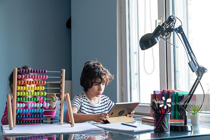 兄妹在客厅里在家上学图片素材