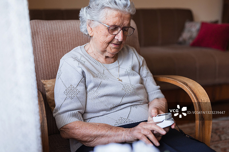 使用指式血压监测器的老年妇女图片素材