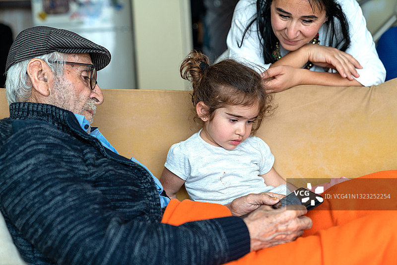 曾祖父和曾孙女使用智能手机图片素材