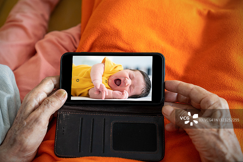 曾祖父和曾孙女使用智能手机图片素材