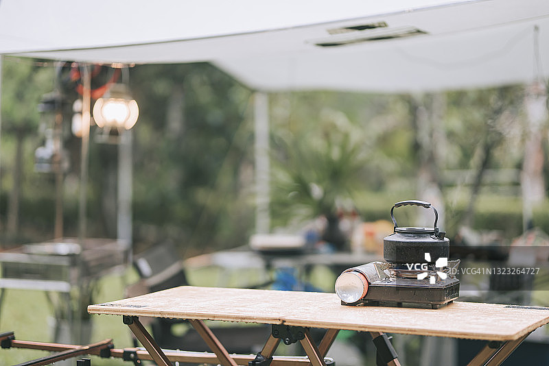 野餐桌上的露营炉和热水壶图片素材