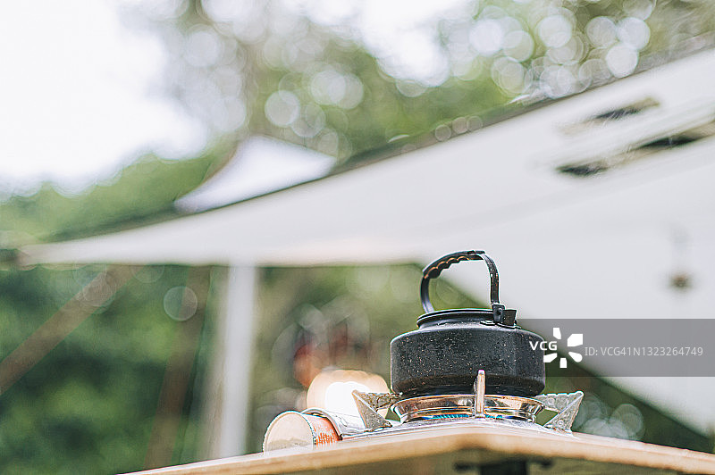 野餐桌上的露营炉和热水壶图片素材