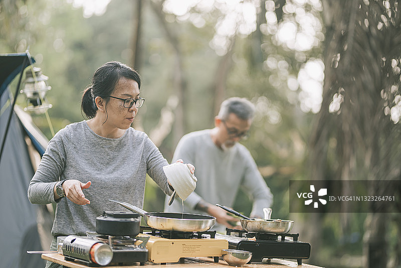 中国老年夫妇准备户外露营早餐图片素材