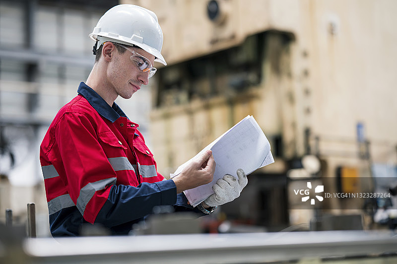 白人工程师在汽车零件生产线上查看生产日报图片素材