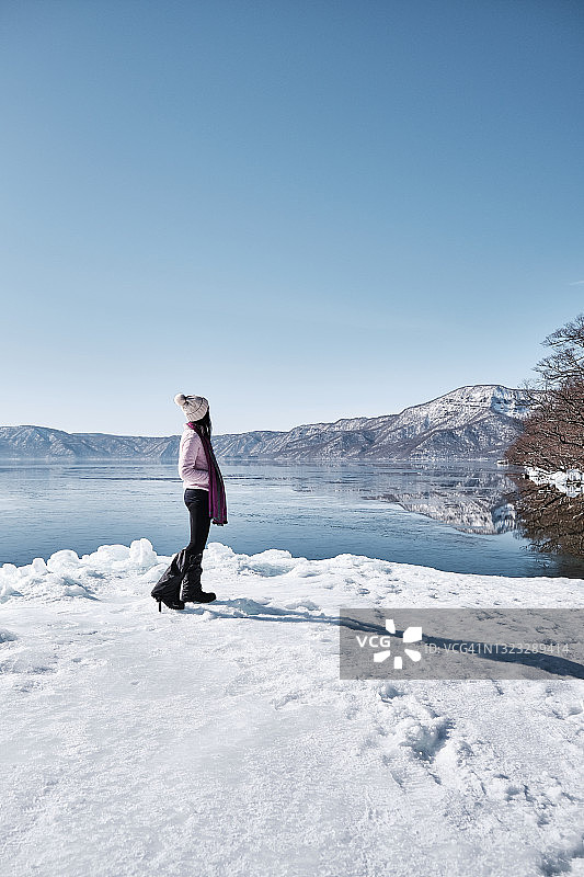 女人欣赏冬季的十和田湖图片素材