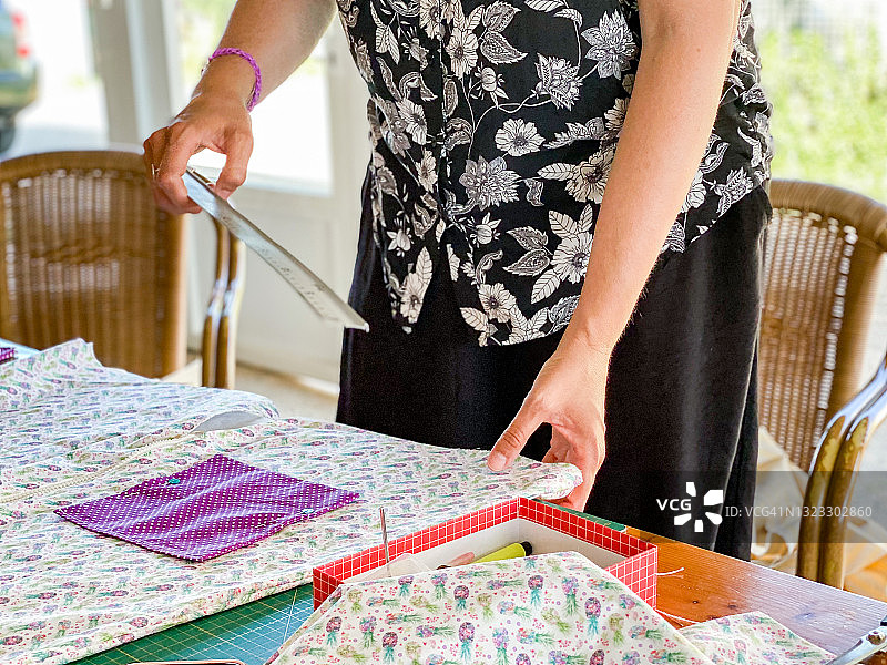 在露台上用缝纫机缝纫的女人图片素材